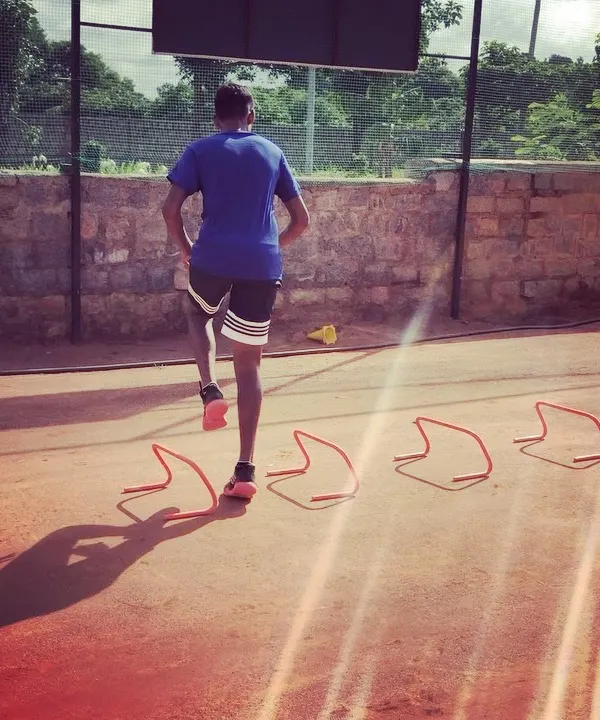 An advanced player works on his agility and speed with hurdle drills. This type of plyometric training is essential for explosive movements on the court.