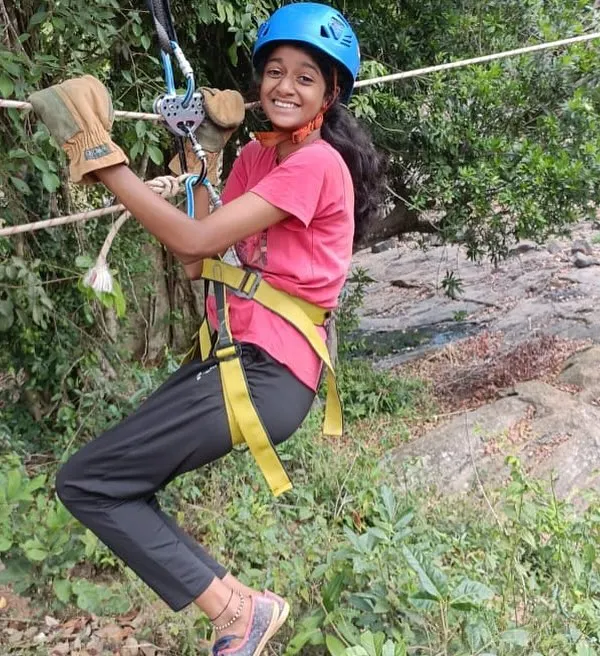A young participant smiles as she glides across on a zipline. Our youth camps are filled with thrilling activities that are both safe and incredibly fun.