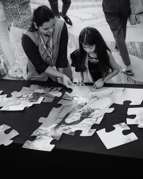It's the little things that matter most. Here, a young guest is engaged with a custom jigsaw puzzle featuring a photo of the couple.