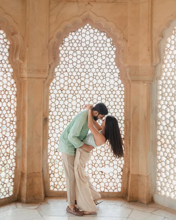 A tender embrace framed by a magnificent latticed archway in Jaipur. We masterfully use natural light and architecture to create these breathtakingly romantic and timeless pre-wedding portraits.