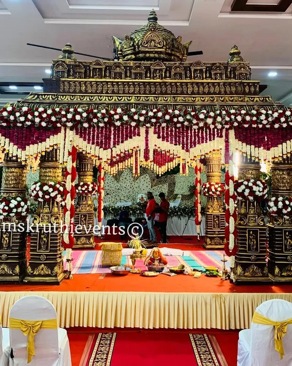 This grand, temple-style wedding mandap is one of my signature designs. The intricate pillars, combined with rich red and white floral garlands, create a truly divine and traditional atmosphere for the main ceremony.