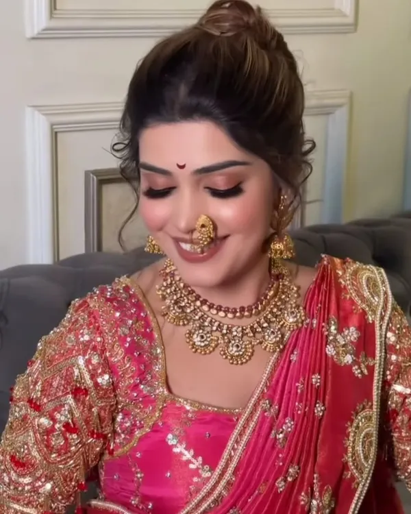 A classic Maharashtrian bridal look, complete with a traditional *nath* and bindi. I focus on creating a flawless, radiant base with soft, elegant eye makeup that enhances your natural beauty for your special day.