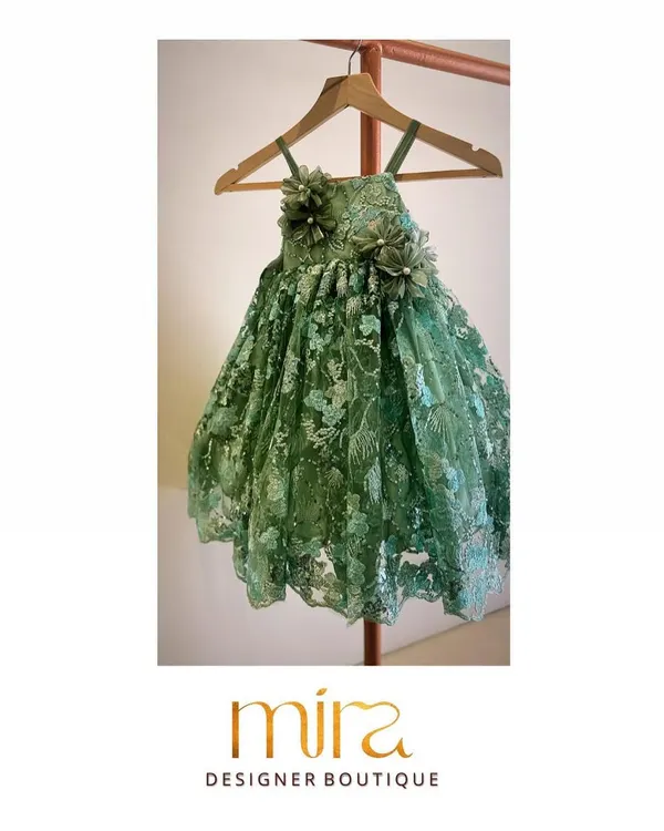 I designed this custom birthday dress in an elegant green net fabric for a client's daughter. The piece features intricate floral embroidery and delicate 3D flower appliqués on the bodice, creating a truly magical look for her special celebration.