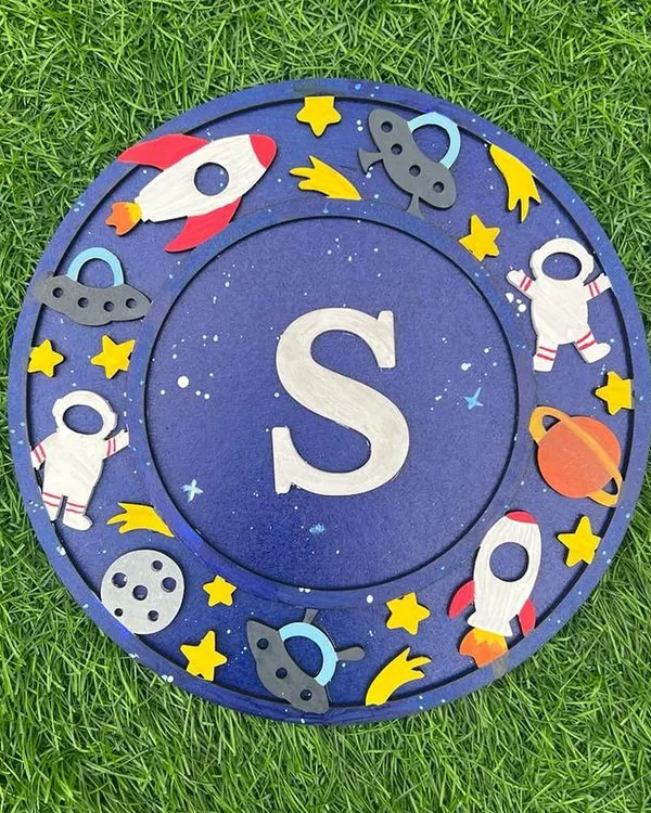 Create a stellar piece of decor with my space-themed monogram kit. This "S" plaque is surrounded by hand-painted astronauts, rockets, and planets. It's the perfect personalized project for any aspiring space explorer.