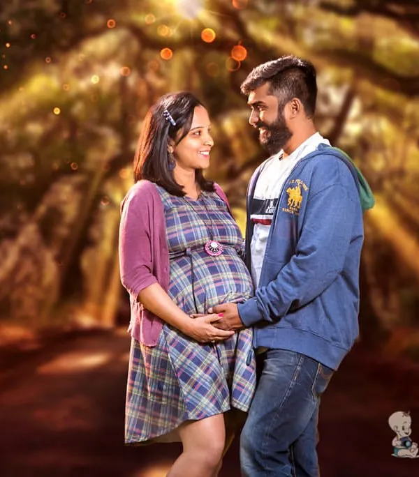 I love using natural landscapes to create a magical feel. Here, a couple shares a quiet moment on a tree-lined path, with soft lighting adding a touch of enchantment to their pregnancy portrait.