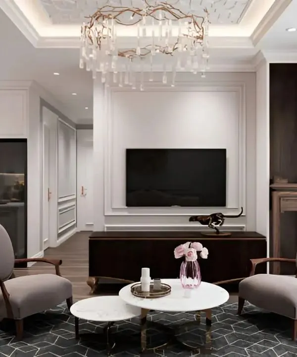 A neo-classical living room featuring elegant wall mouldings, a crystal chandelier, and a balanced furniture layout.