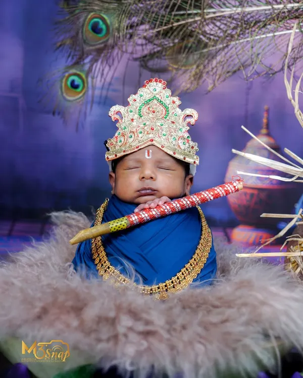 My little Krishna. This is one of my most requested themes. This newborn is dressed as Lord Krishna with a crown and flute, sleeping peacefully against a divine backdrop.