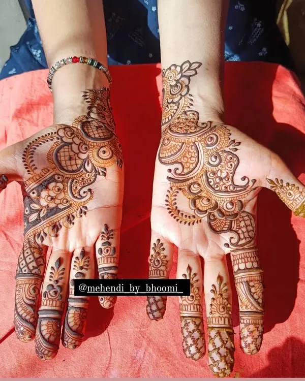 This is a perfect example of a modern Arabic mehendi design. The patterns on both hands are different yet balanced, with bold floral and paisley vines that leave some skin showing for a contemporary look.