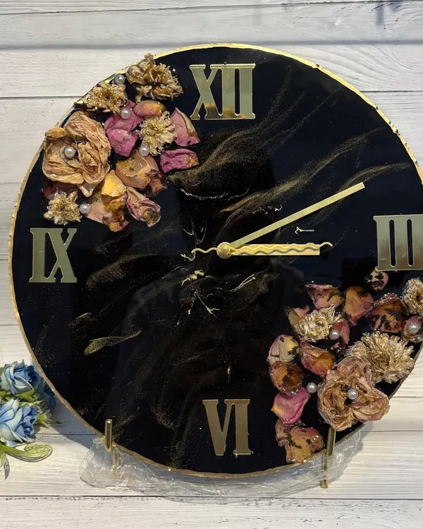 This handcrafted resin clock features a dramatic black and gold design. I've preserved flowers in a crescent shape, creating a bold and elegant statement piece for your wall.