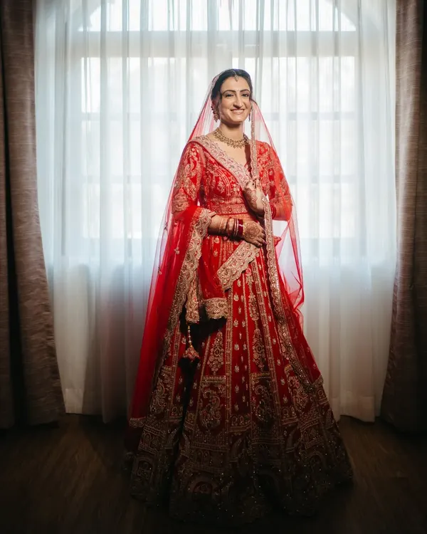 The classic red lehenga, the gentle smile, the quiet anticipation. I believe in capturing the timeless grace of a bride. This is more than a photo; it's an heirloom, a memory of the moment you stood on the threshold of forever.