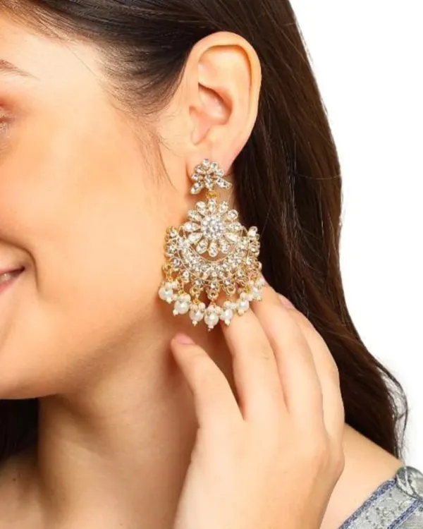 A model showcasing our stunning kundan and pearl earrings. These are designed to be large and impactful, perfect for a wedding or festive event, yet feel comfortable to wear.