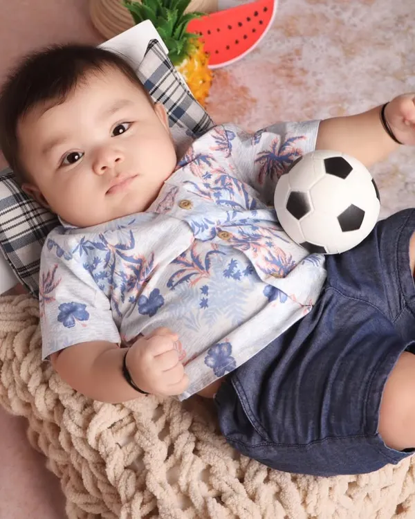 This six-month-old sitter was an absolute star during his beach-themed studio session. His relaxed pose and sweet expression perfectly capture the calm and happy nature of this milestone age.