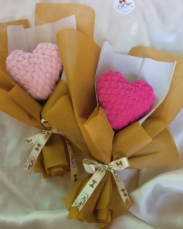 Two of our plushie heart bouquets side by side, one in a soft baby pink and the other in a vibrant magenta. They show the different color options available for this unique gift.