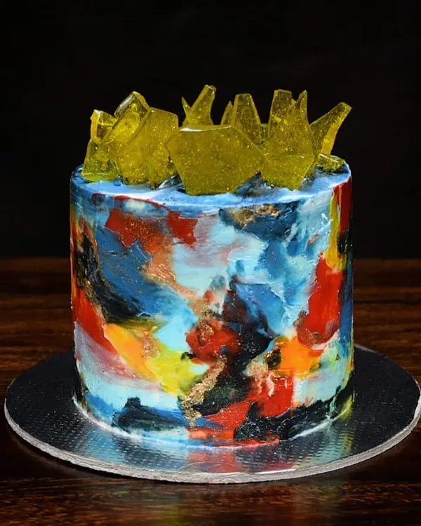 This cake is like an edible canvas. I used a palette knife with different colored buttercream to create this abstract, textured art piece, topped with shards of yellow sugar glass for a modern look.