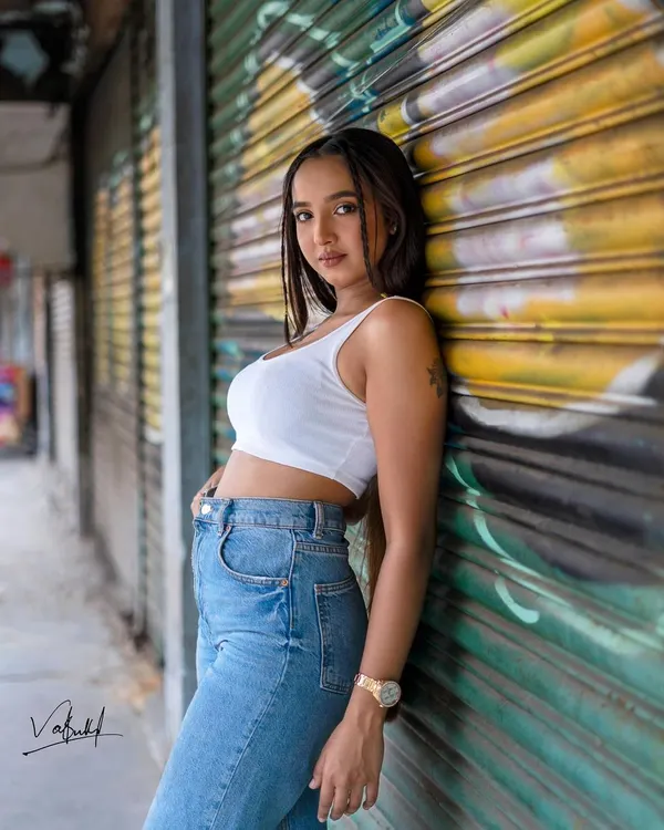 Using the vibrant colors of a graffiti-covered wall as our canvas. This street fashion shot has a bold, artistic energy that perfectly matches the model's confident pose.