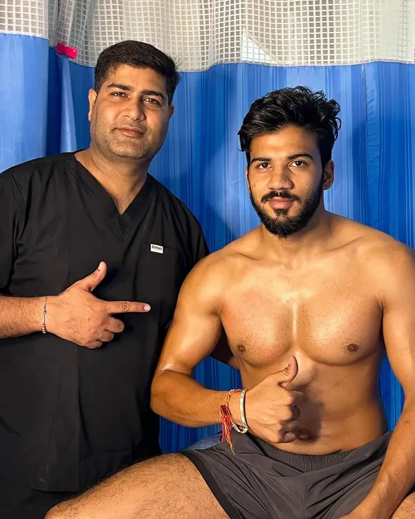 A happy client giving a thumbs-up after his muscle recovery session.