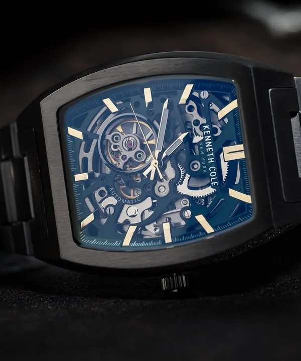 A detailed macro shot of a Kenneth Cole watch, focusing on the complex inner mechanics. This highlights the product's quality and is essential for luxury watch photography.