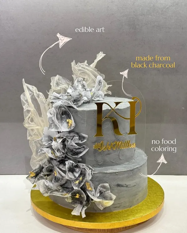 This two-tiered architectural cake is a testament to my philosophy of pure indulgence. The elegant grey hue is achieved naturally using black charcoal, and the cake is adorned with delicate, edible fabric art and a custom gold monogram, all without any artificial food coloring.