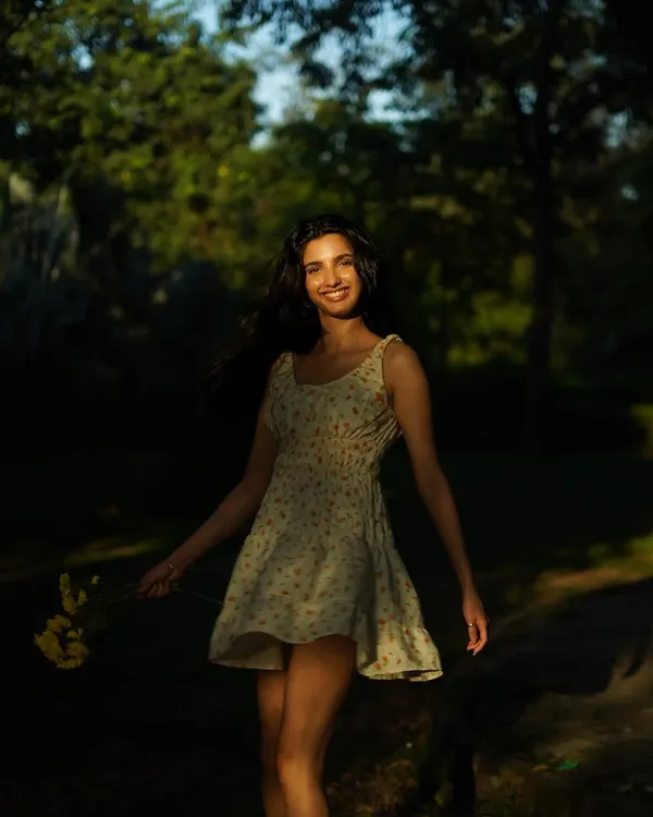A beautiful, candid-style portrait in a sun-dappled park. The play of light and shadow creates a dreamy, natural mood for this simple summer dress.
