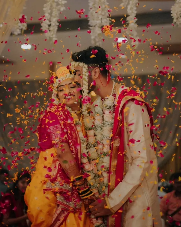 A candid moment of pure bliss as the couple is showered with flower petals. This is the kind of joyful, unposed shot I aim to capture.