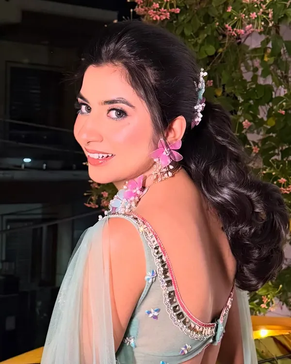 Surbhi, looking fresh and beautiful for her Mehendi. The pink floral jewelry is complemented by soft pink tones in her makeup.