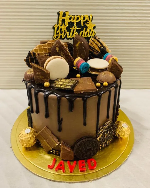 Drooling over this! A chocolate truffle cake overloaded with a variety of treats including macarons, Oreos, wafers, and different kinds of chocolates.