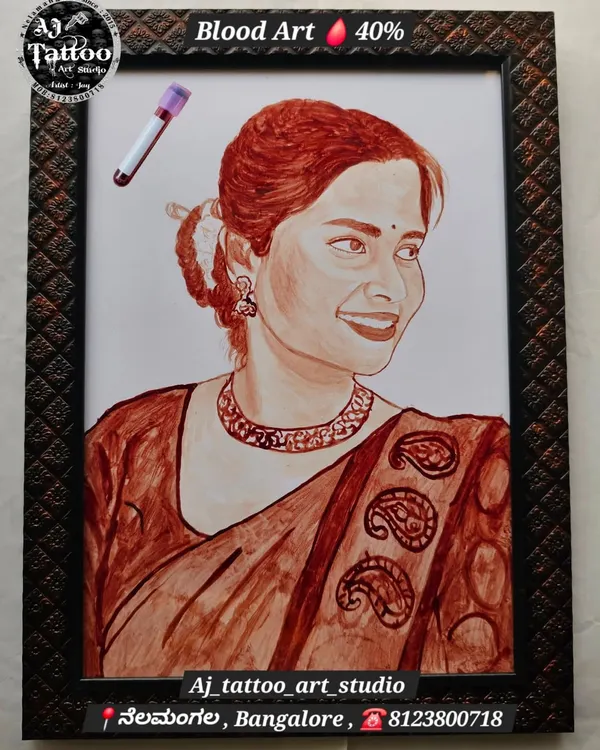 A beautifully detailed blood portrait of a woman in a traditional saree. The artwork captures her gentle smile and the intricate patterns of her clothing, all framed and ready to display.