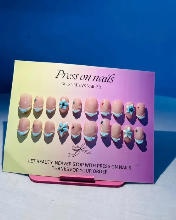 A full view of my 3D shell art press-on nails. The combination of the French tip style with the hand-sculpted blue flowers creates a fresh, beach-inspired look.