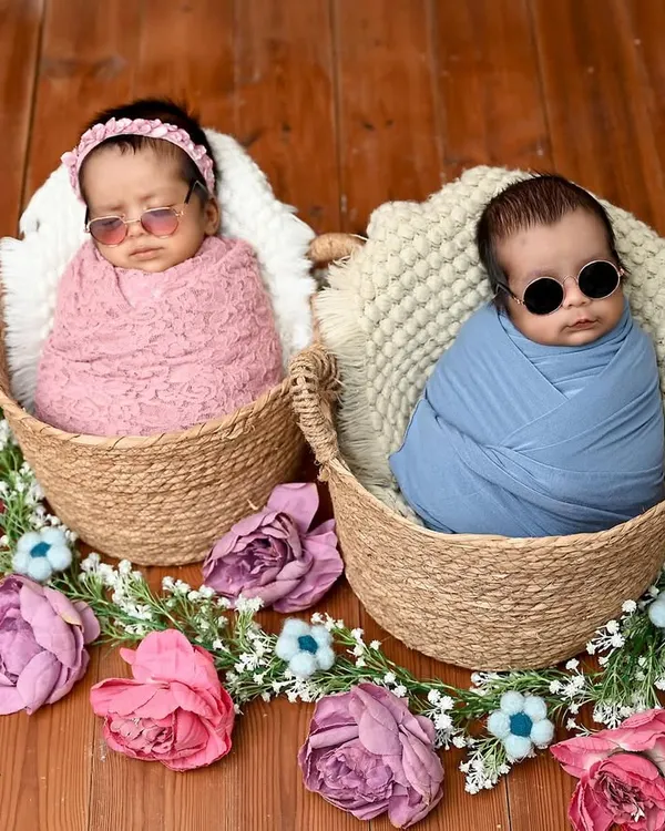 Too cool for school. These twin newborns are rocking tiny sunglasses in their individual baskets, showing off their personalities even at this early age.