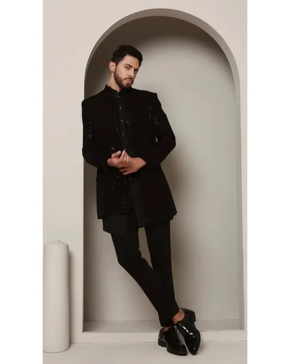 The Celectial Shrug Set in all black. This ensemble features an asymmetrical kurta paired with a meticulously embroidered shrug, creating a look of contemporary sophistication.
