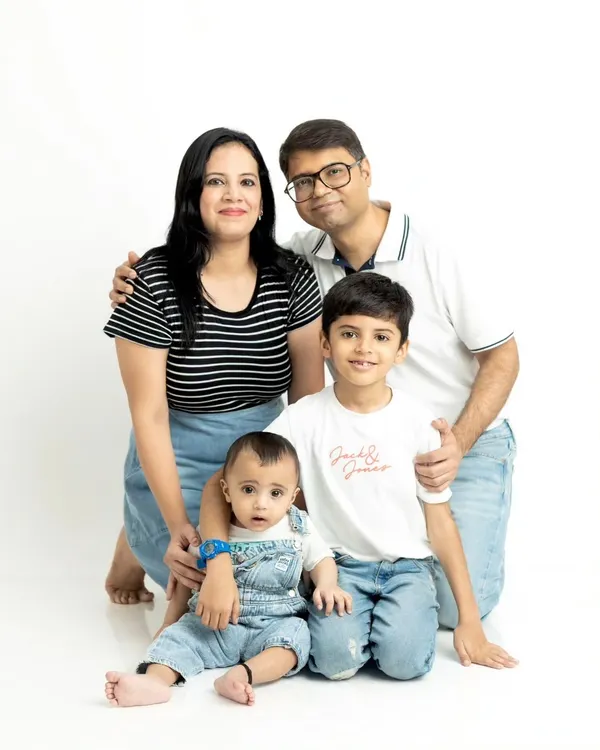 A classic family portrait against a clean white studio background. We posed this family of four to create a timeless image highlighting their connection.