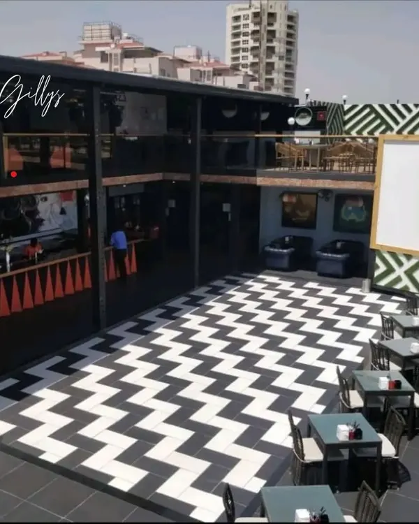 An overview of the Gilly's project, showing the bold black-and-white chevron flooring and the multi-level layout designed for a dynamic pub experience.