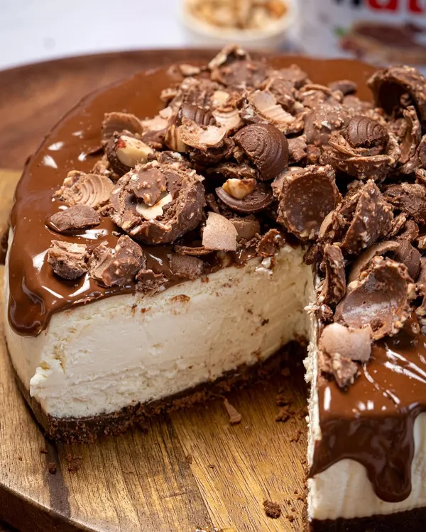 A perfect slice of my Nutella Ferrero Cheesecake. The creamy, smooth cheesecake filling sits on a chocolate biscuit base and is topped with a generous layer of Nutella and crushed Ferrero Rocher.