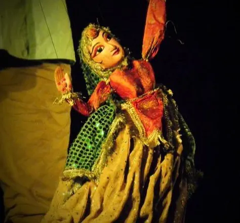 This is Anarkali, a traditional Rajasthani string puppet, captured during a performance. Her face is hand-painted on wood, and her costume is stitched with great care to allow for graceful dance movements, bringing the character to life under the stage lights.