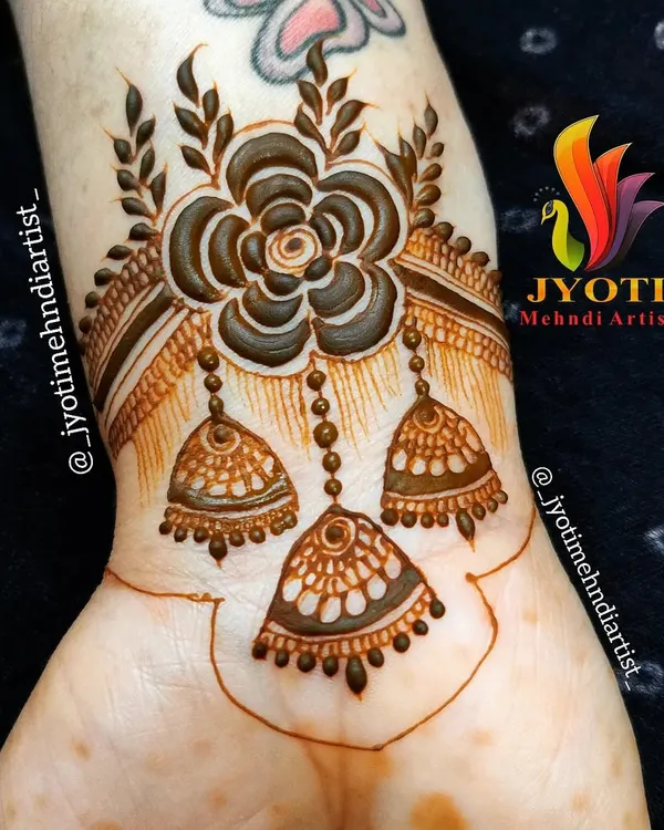 A beautiful and creative wrist cuff design featuring a large flower with dangling jhumka (earring) motifs. This jewelry-inspired piece is a unique and stylish choice.