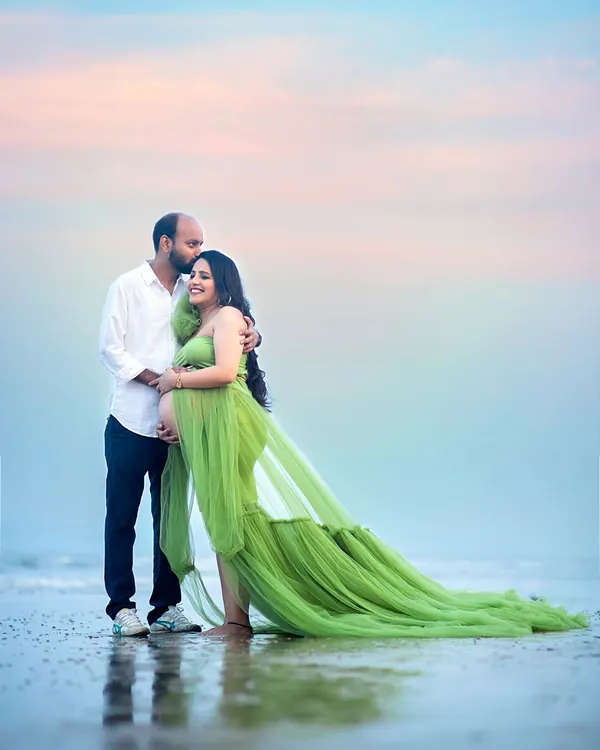 A tender kiss on the forehead against a pastel sky. This beach maternity photo captures the quiet intimacy and anticipation as the sun sets over the water.