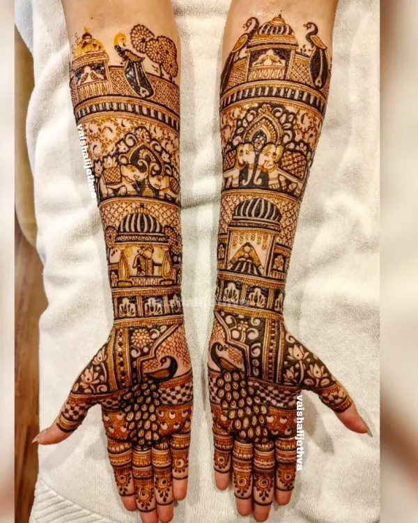 A full bridal design telling a royal story. This piece includes scenes from a wedding procession, with elephants, palaces, and doli motifs covering the hands and arms.