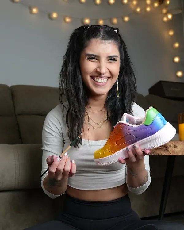 This is me in my happy place. A candid shot of me holding up a freshly painted rainbow sneaker, brush in hand. This is what it's all about.