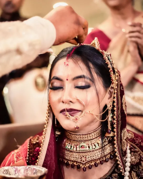 A close-up shot of the sindoor daan, one of the most significant moments in a Hindu wedding. I focus on the bride's serene expression as the vermilion is applied, capturing the deep emotion and sanctity of this ritual.