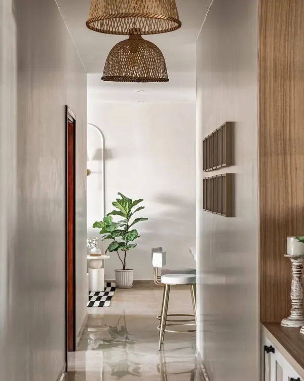 This hallway design is a perfect blend of style and function. The white walls and pendant lights create a bright and inviting path, while the plants add a touch of nature.