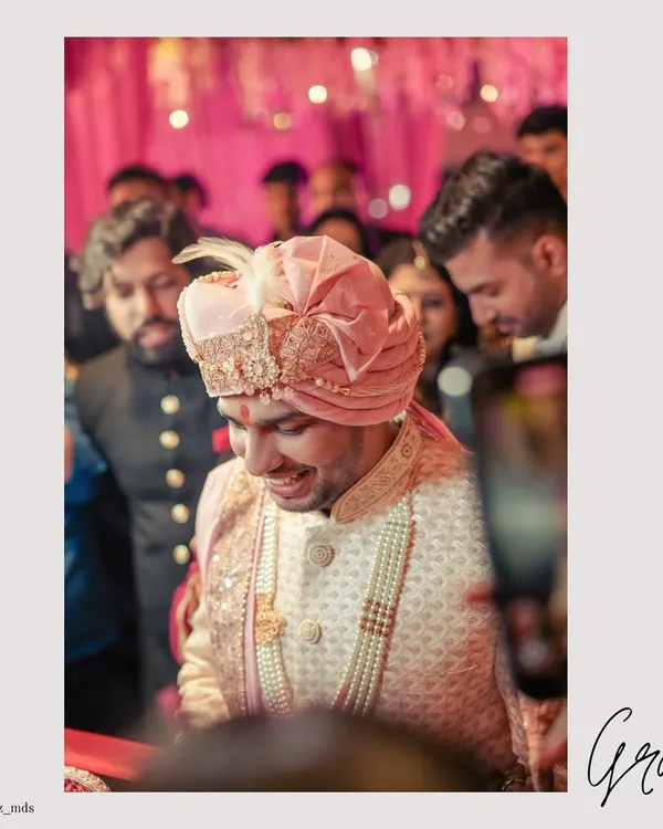 A candid shot of the groom's entry, his happy smile capturing the excitement of the moment.