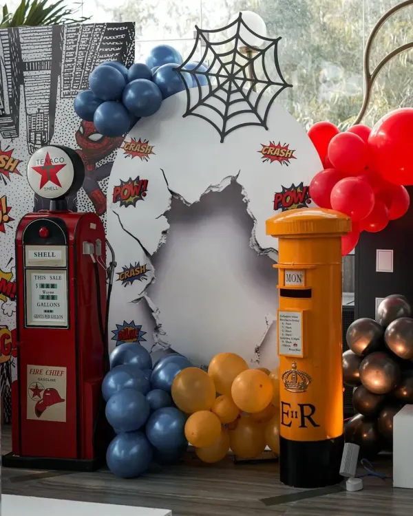 POW! This Spider-Man themed photo booth is ready for action, featuring a broken-wall effect, a spider web, and classic comic book sound effects.