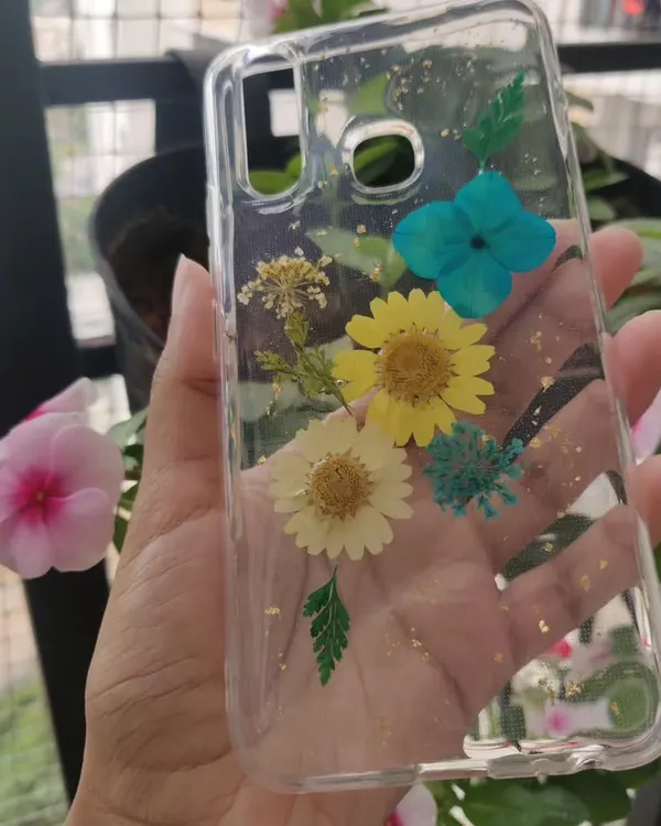A custom phone case made with real dried flowers. I arranged these yellow and blue daisies and added a sprinkle of gold leaf to create a beautiful, botanical design.