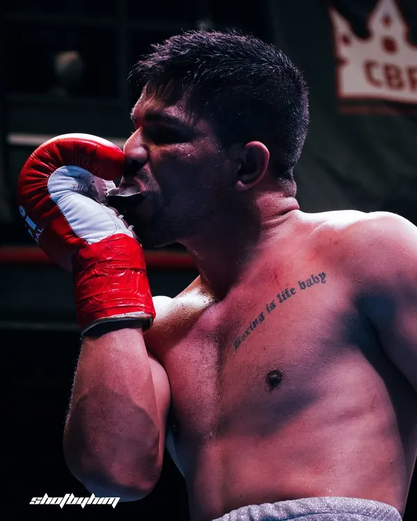 This is what it's all about. The passion, the dedication, and the quiet moment of respect for the sport. My goal is to capture the soul of the fighter, not just the fight, and this shot says it all.