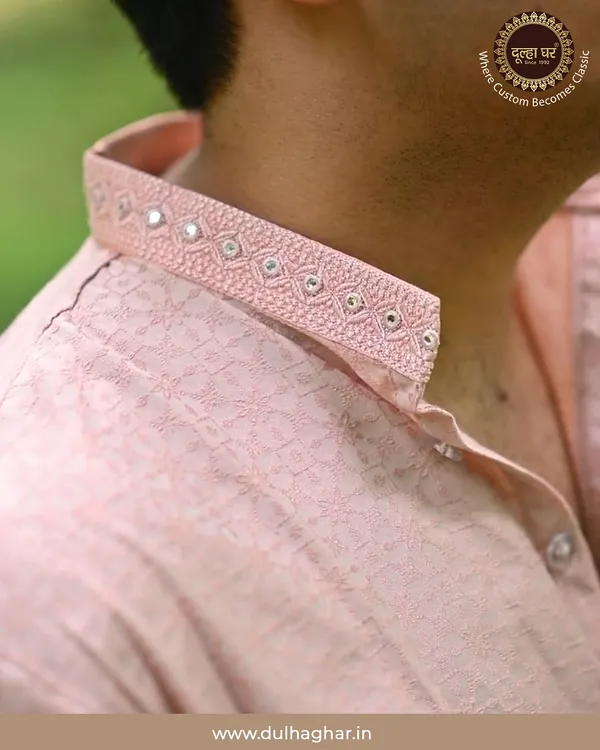 Royal weddings begin with royal style. A close-up on the collar of a pink kurta, showcasing delicate mirror work and embroidery.