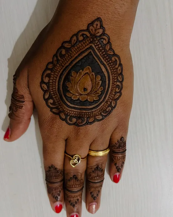 This is a beautiful and quick backhand design. It features a central lotus motif inside an ornamental drop shape, with simple details on the fingers, making it perfect for any party.