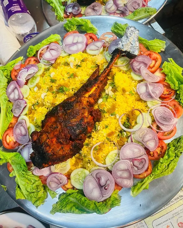 Our showstopping Mutton Mandi. A whole leg of mutton, slow-cooked and spiced, served on a bed of fragrant rice. A true centerpiece for any feast.