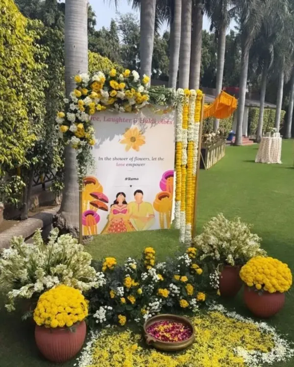 A personalized welcome sign for a Haldi function. The sign is placed on an easel and decorated with yellow and white flowers, warmly greeting guests as they arrive.