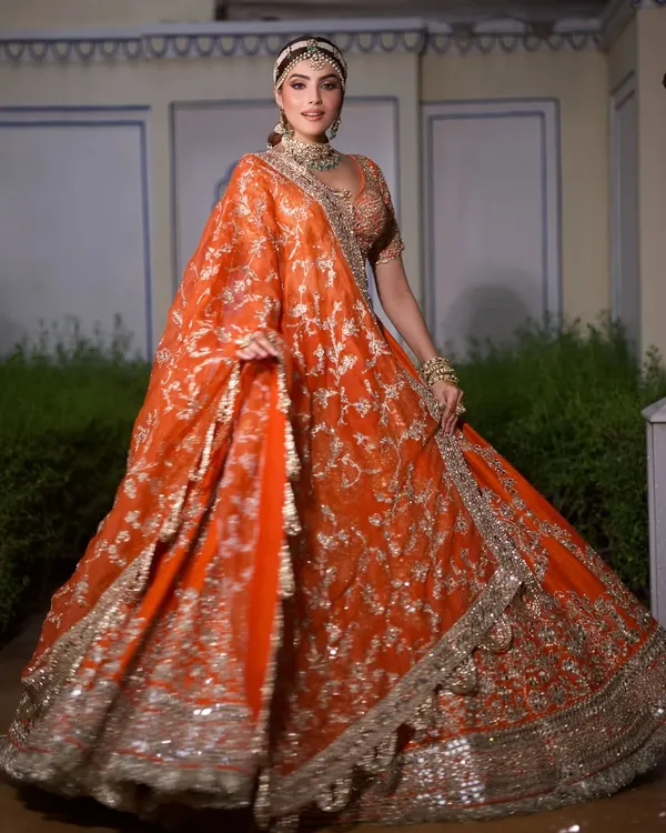 A stunning, vibrant orange lehenga by Abhinav Mishra, perfect for a grand Mehendi celebration. The wide flare of the skirt is designed for that perfect twirl.