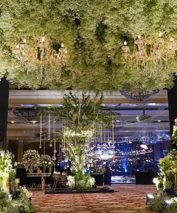 We created a forest of baby's breath for a landmark 70th birthday celebration. The entrance featured a breathtaking ceiling of white florals and chandeliers, leading into a space designed for honoring a lifetime of memories.